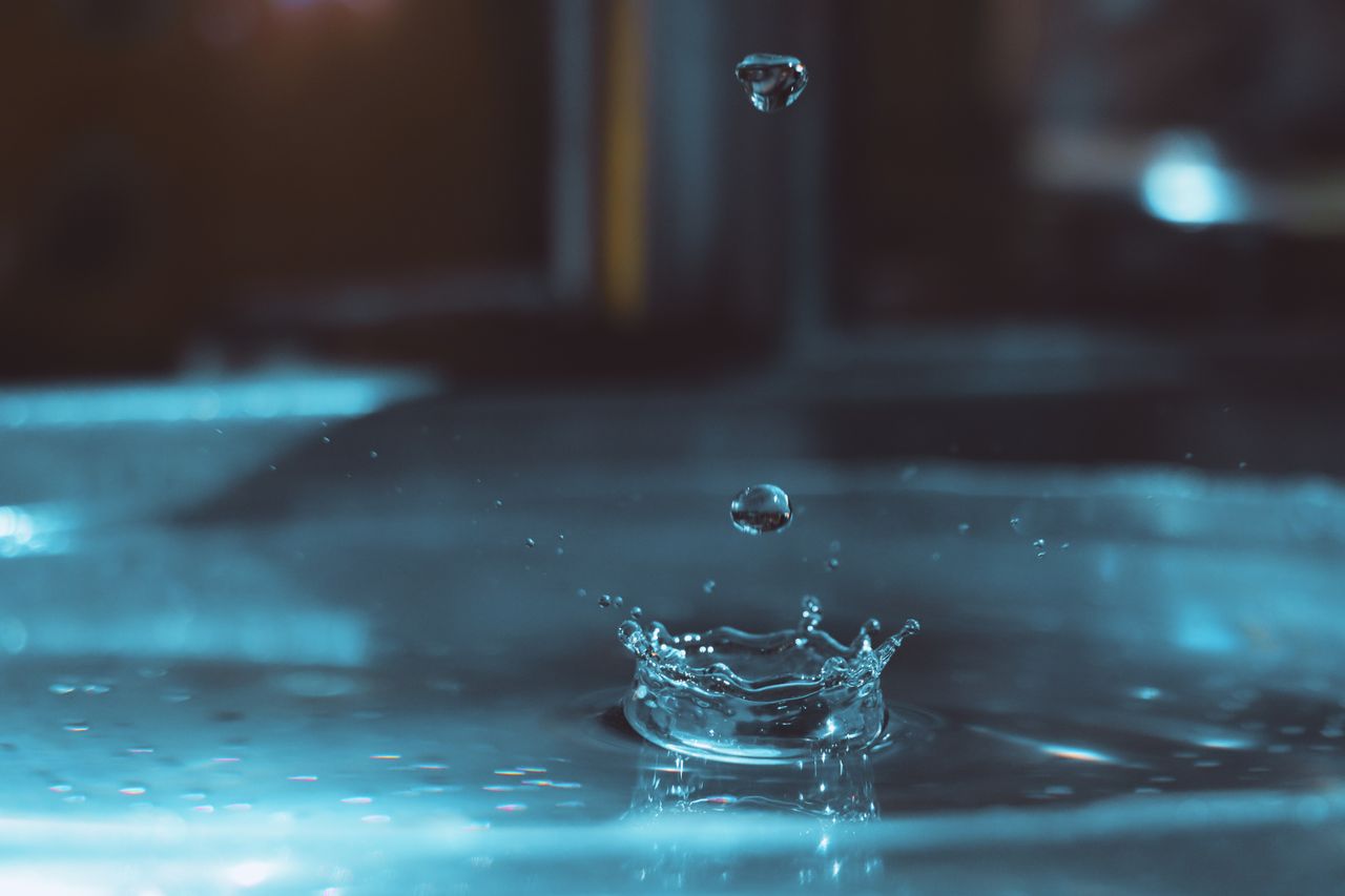 Residential Services Close-up capture of water droplets splashing with a vibrant blue tone.