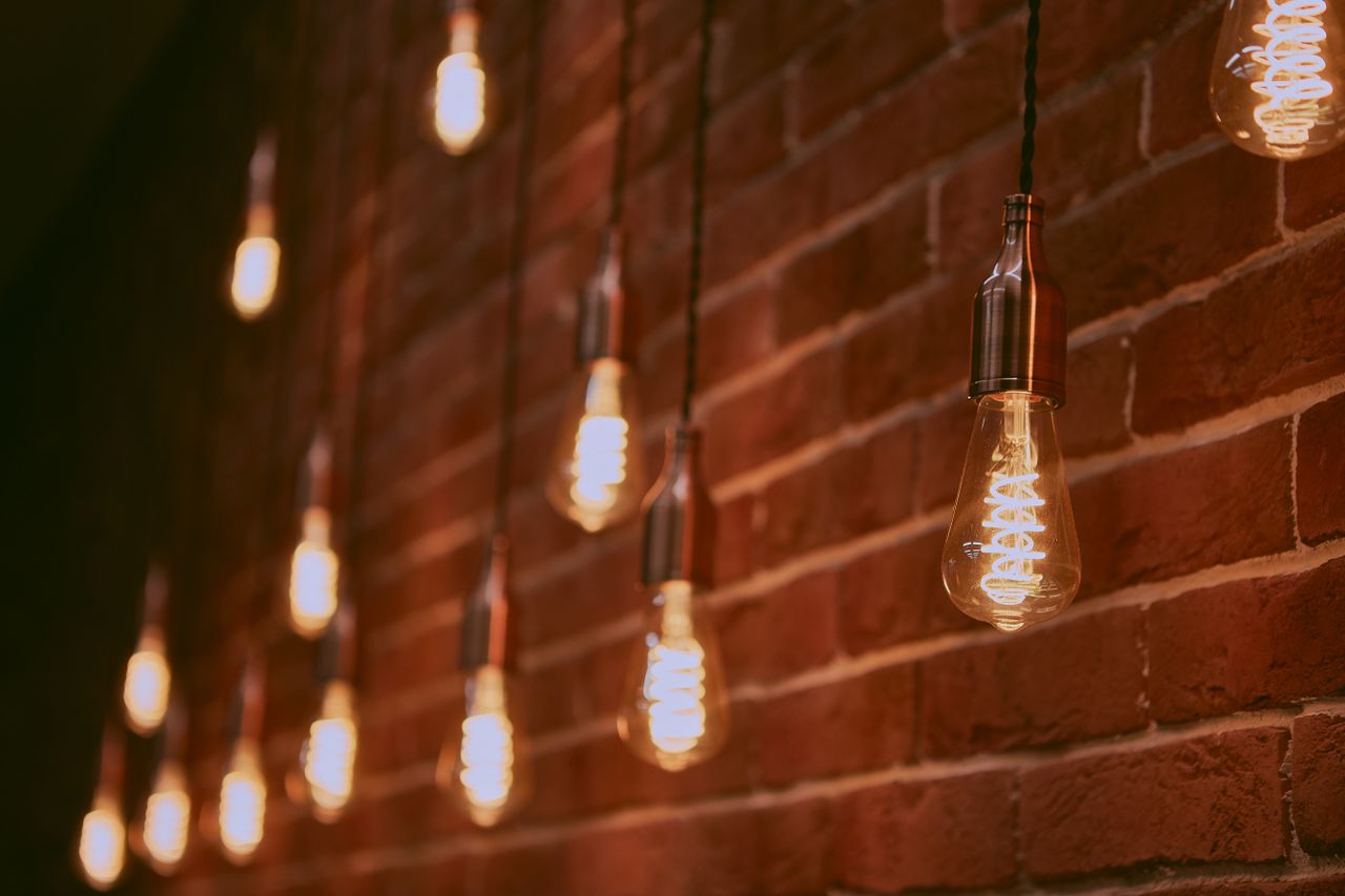 The Art of Drawing Readers In: Your attractive post title goes here Selective focus of bright glowing lamps hanging on brick wall of modern building